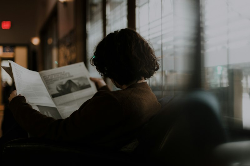 Mujer leyendo un documento junto a la ventana